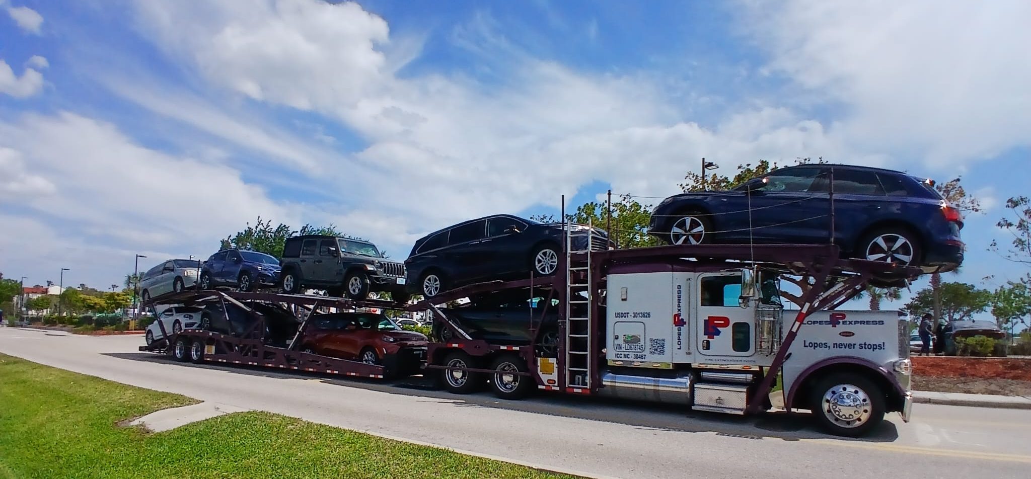 A Lopes Express car hauler loaded with nine cars on a Florida road